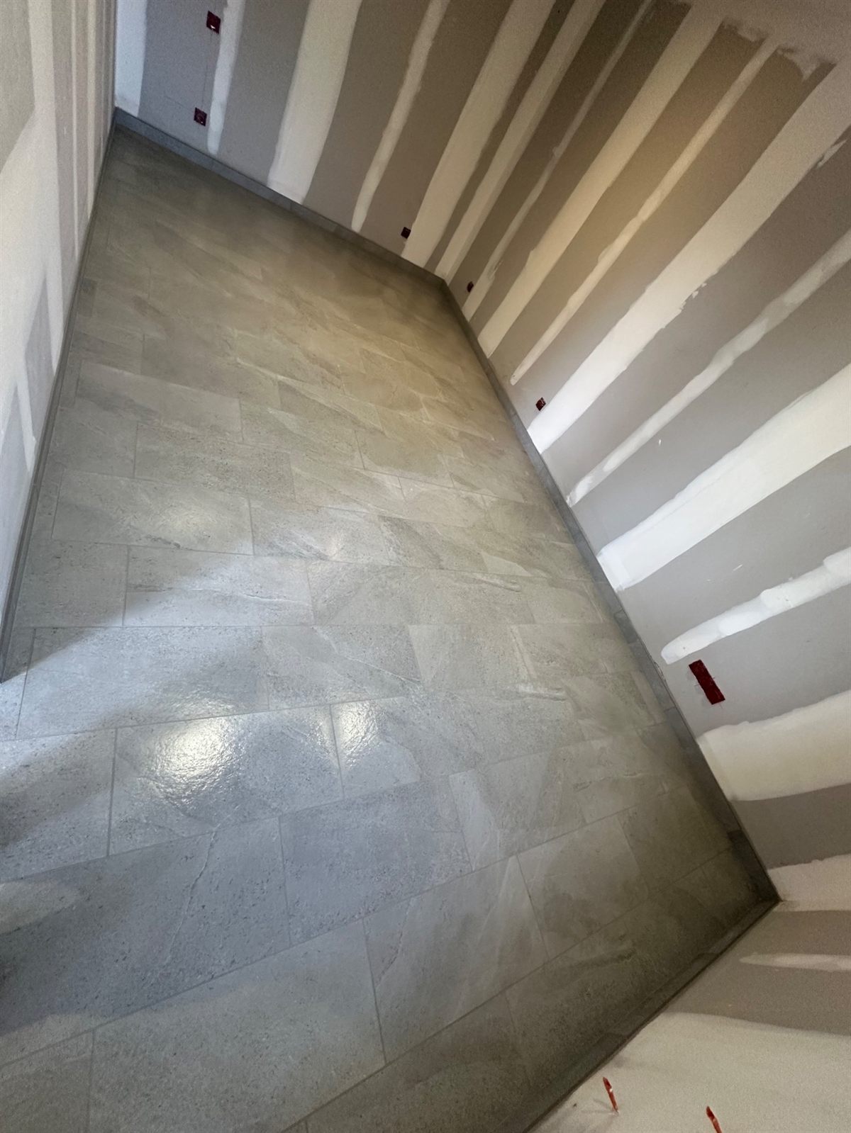 Carrelage grand format posé sur un palier d'escalier