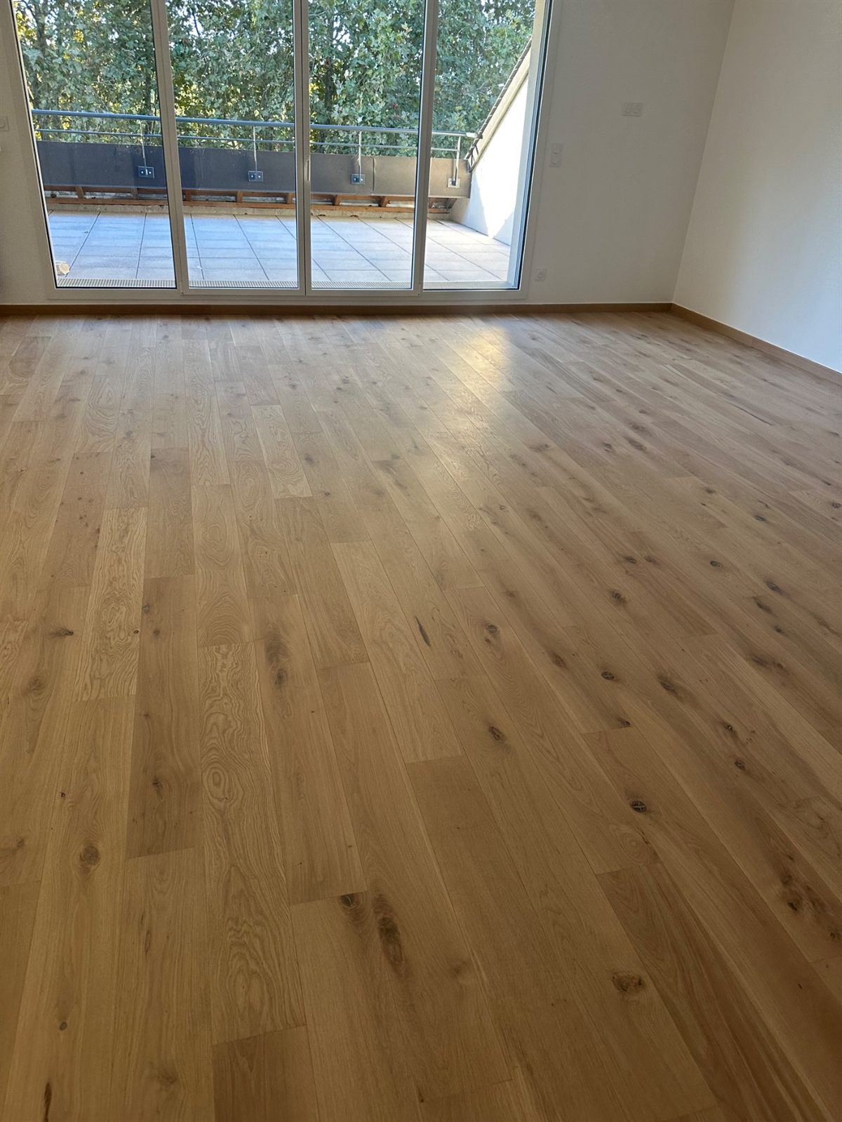 Parquet posé dans un séjour avec baie vitrée